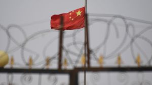 Den kinesiska flaggan över ett internerimgsläger i Xinjiang Den kinesiska flaggan över ett internerimgsläger i Xinjiang