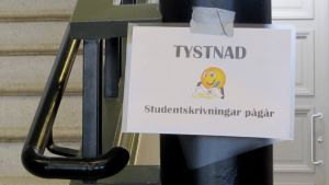 Det är gymnasiets tvåor som får fungera som provkaniner under testet. Skylt med texten "Tystnad, studentskrivningar pågår".