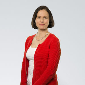 Ett förbud bryter mot personalens yttrandefrihet, säger fackföreningen OAJ:s arbetsmarknadsjurist Kristiina Tuhkiainen. En kvinna mot en grå bakgrund.