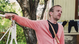 Mahdollisia asukkaita voisivat olla esimerkiksi tietotyöläiset, jotka tekevät töitä osittain kotoaan käsin, sanoo Samuli Välimäki. Pihakeinussa takapihalla istuu nainen ja vieressä seisoo keinuun nojaten mies, kesäiset vaatteet, vehreä piha