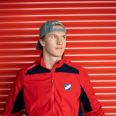 Anton Lundell står framför en röd vägg.