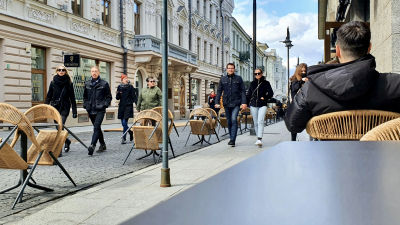 Flera par kommer vandrande emot på en gågata i Vilnius i Litauen med coronasäkerhetsavstånd mellan paren.