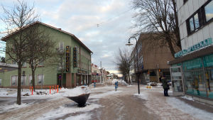 Till exempel längs med Köpmansgatan kunde det komma nya bostäder. En snöbeklädd gågata.På sidorna syns olika byggnader med affärer i bottenplan.