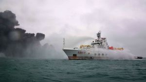 Räddningsbåtarna har problem med att nå fram till oljetankern. Räddningsbåt på havet i närheten av den brinnande oljetankern.