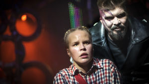 Riddar Kato ( Mika Fagerudd) hotar och hånar den skräckslagna Mio ( Malin Olkkola). Riddar Kato ( Mika Fagerudd) hotar och hånar den skräckslagna Mio ( Malin Olkkola)
