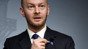 Sampo Terho visar upp ett sannfinländskt pins han tagit som minne. Sampo Terho visar Timo Soini Sannfinnländarna-pins som Soini kastat bort.