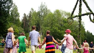 Ihmisiä tanssimassa juhannussalkon ympärillä
