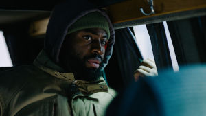 In the heat of the night. Francis (David Nzinga) befinner sig ständigt på flykt, Francis i baksätet på en bil som kör genom natten.