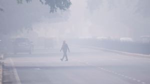Den värsta smogen på många år: Hostande människor skyddar sig mot den svidande luften, skolor stängs, bilar förbjuds att köra och byggverksamhet avstannar. En man korsar en gata i New Delhi 4.11.2019. Hostande människor försökte skydda sig mot svidande smog, skolor stängdes, bilar förbjöds att köra och byggverksamheten avstannade.