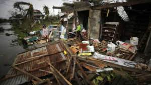 Bybor vid sitt förstörda hem. Ett filippinskt par inspekterar sitt hem som förstörts av tyfonen Mangkhut.