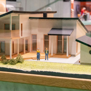 En miniatyrmodell av ett bostadshus i en glasmonter