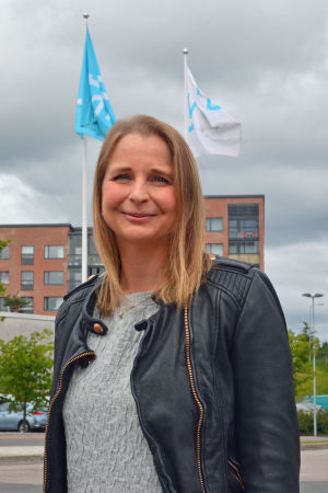 Sanna Tegengren poserar framför Yles flagstänger.