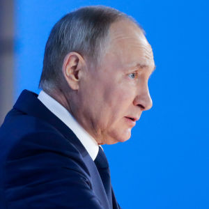 President Putins politik har mycket osynligt stöd bland inflytelserika byråkrater. Vladimir Putin vid en talarstol.
