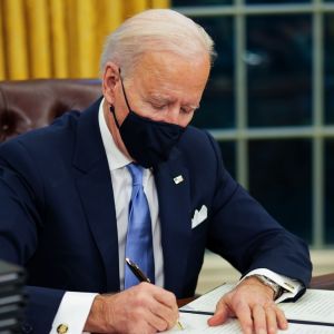 President Biden satte genast igång med arbetet i ovala rummet. Joe Biden sitter vid skrivbordet i Ovala rummet och undertecknar dekret.