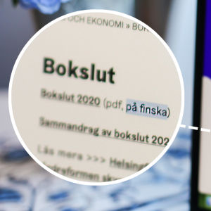 I förgrunden syns Helsingfors stads hemsida där man kan läsa bokslut, endast på finska. I bakgrunden syns en suddig vas med blommor.