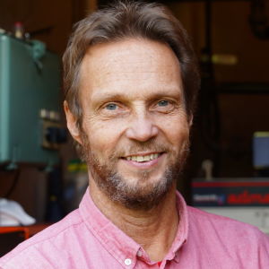 Jan-Erik Nordlund tittar in i kameran. I bakgrunden syns en oljepanna.