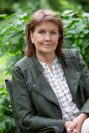 Författare Benita Backas-Andersson sitter i trädgård