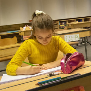Skolelever i Salo svenska skola sitter vid pulpeten och skriver. 