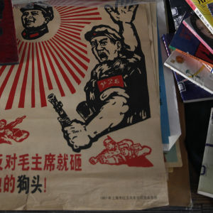 Gamla föremål från kommunisttiden säljs på en loppmarknad i Peking. Texten på affischen säger att alla som motsätter sig Mao Zedong ska krossas.