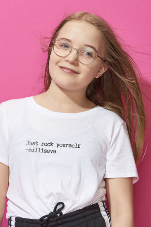 Milla poserar leende med huvudet böjt lite till vänster.