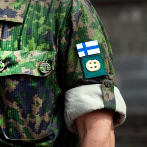 Suomen lippu puolustusvoimien everstin maastopuvun hihassa.