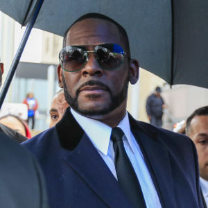 R Kelly i solglasögon och kostym utanför en domstol.