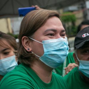 Sara Duterte iklädd munskydd omgiven av människor
