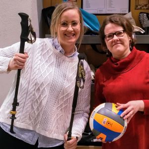 Två kvinnor med idrottsredskap i händerna.