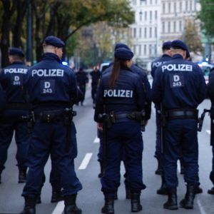 Flera österrikiska poliser står på rad på en väg.
