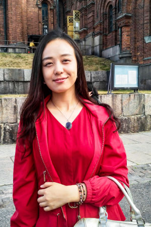 - Kyrkan är ovärdelig, så en liten avgift skulle vara okej, tycker turisten Keke Li från Kina. Keke Li står framför Uspenskijkatedralen i Helsingfors. Hon ser nöjd ut.