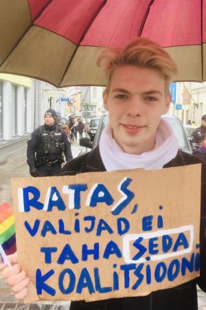 Artjom är orolig. På plakatet står det: "Ratas (premiärministern), väljarna vill inte ha den här koalitionen". Artjom demonstrerar mot den kommande regeringen i Estland.