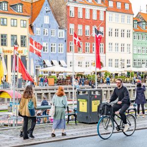 Människor går och cyklar vid vattnet i Köpenhamn.