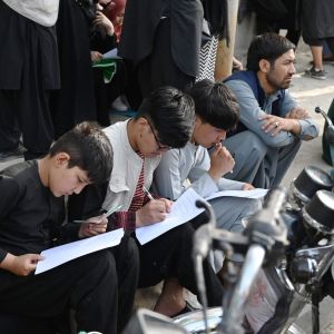 Afghaner fyller i dokument för att kunna lämna landet. utanför den brittiska och kanadensiska ambassaden i Kabul 19.8.2021