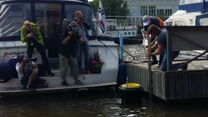 Flera fotografer följer med då Pete Ceglinski sätter fast havssoptunnan vid en brygga i Åbo gästhamn. Flera fotografer följer med då Pete Ceglinski sätter fast havssoptunnan vid en brygga i Åbo gästhamn.