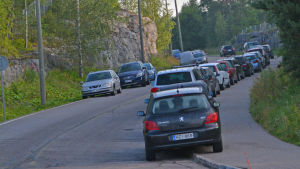 Kalkstrandsvägen klassificeras inte längre som en farlig väg. Bilar parkerade på båda sidor längs en landsväg.