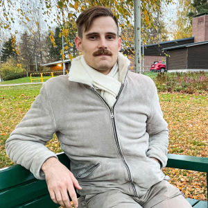 En man som sitter på en bänk.