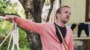Folk som distansjobbar kunde utmärkt bosätta sig här, säger Samuli Välimäki. Pihakeinussa takapihalla istuu nainen ja vieressä seisoo keinuun nojaten mies, kesäiset vaatteet, vehreä piha