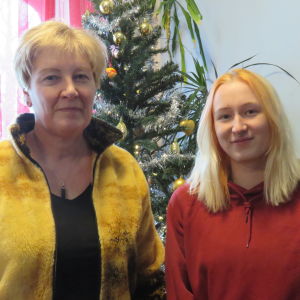 Ann-Maj Gabrielsson och Janina Gabrielsson framför en plastgran dekorerad i silver och guldglitterband och julgransbollar.