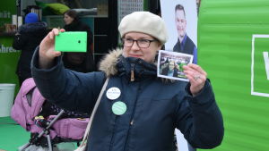 Nora Lindströms kampanj syns också i sociala medier. Nora Lindström tar en selfie med valreklam i handen och en illgrön kampanjvagn i bakgrunden.