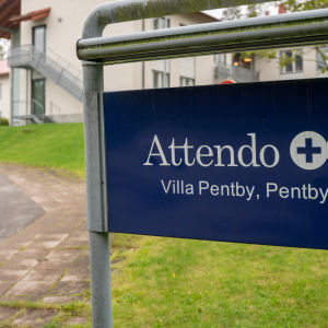En skylt med texten "Attendo, Villa Pentby", i bakgrunden äldreboendet.
