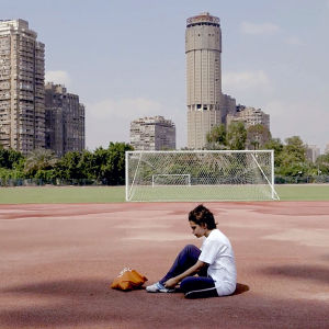 Amal -tyttö istuu urheilukentällä