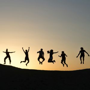 en siluettbild i motljus där sex personer hoppar upp i luften i olika ställningar