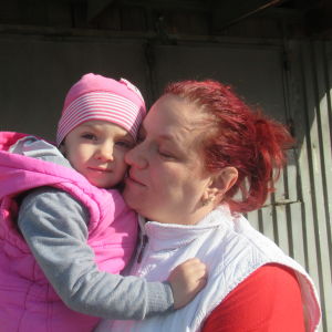 Rödhårig kvinna med med barn i rosa ytterkläder. Adriana med yngsta dottern Sofia.