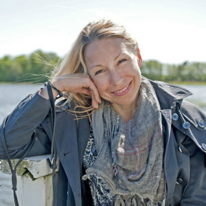 Svenska Yles chef för barnprogrammen, Mikaela Sonck, säger att Arenans och Hajbos someflöden når en stor del av de finlandssvenska barnen. Porträtt av Mikaela Sonck, hav i bakgrunden.