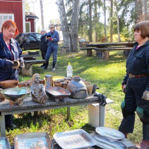 Keramiker Elina Sorainen tillsammans med kollegerna Pia Vuorinen och Ritva Turunen granskar resultatet av den senaste keramikugnsbränningen