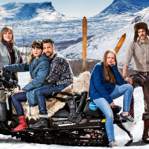 Huvudkaraktärerna i Andra åket vid en snöskoter med fjäll i bakgrunden.
