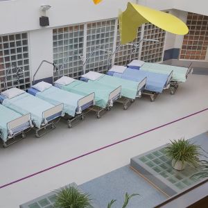 En rad tomma sjukhussängar på en öppen plats i ett sjukhus.