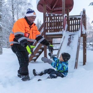 Lamin leikkii lapsensa kanssa lumessa.