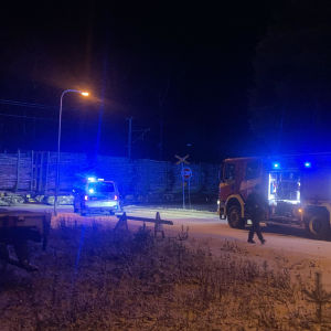 Polisbil och brandbil vid en plankorsning.