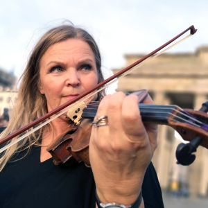 Raakel Lignell soittaa viulua Berliinin muurilla, Brandenburgin portin edessä